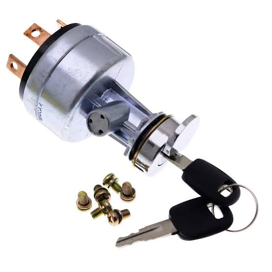 A metallic ignition switch for heavy machinery with two black keys attached and four small mounting screws.